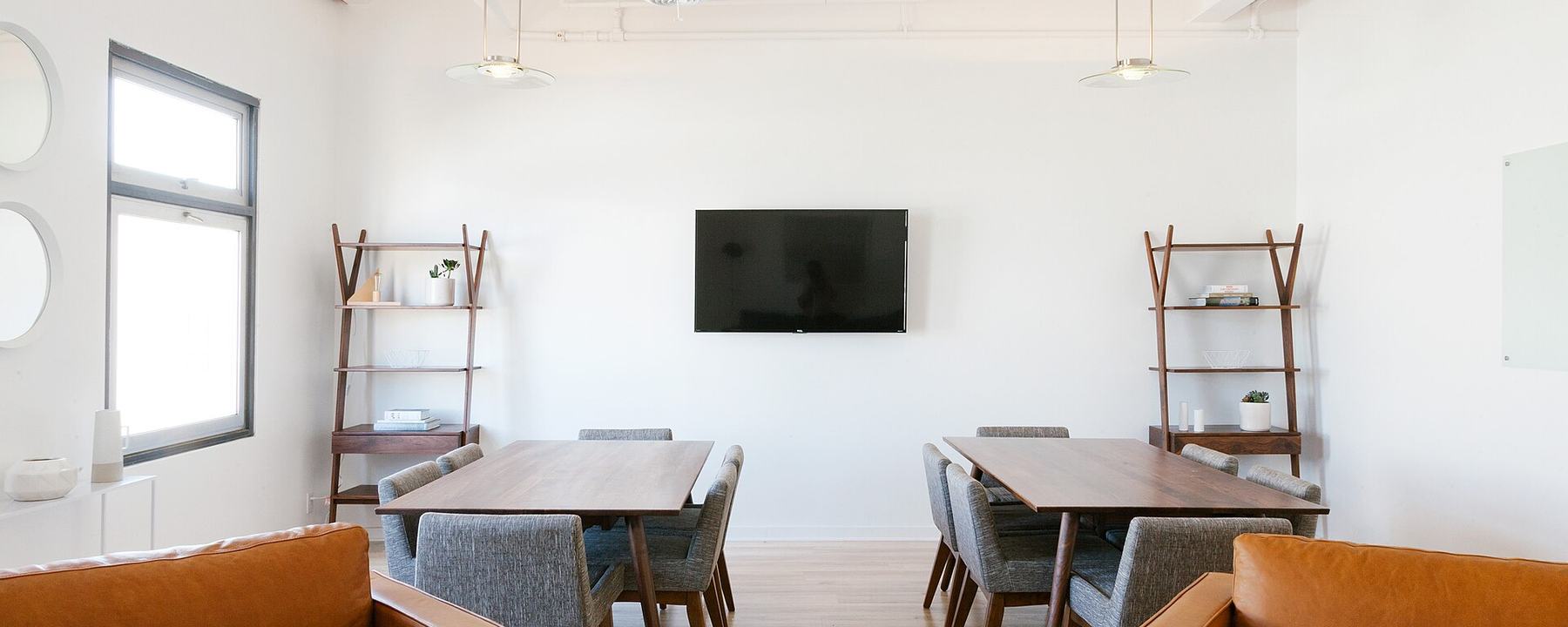 A meeting room with leather chairs around a long wooden table